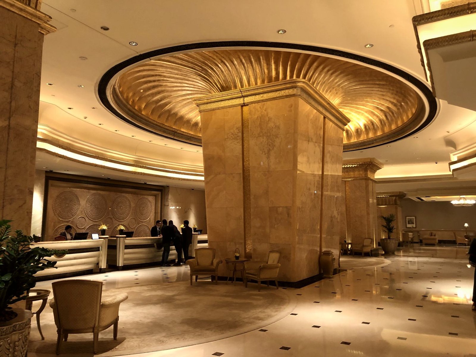 A palace hall with gilded columns beneath a domed ceiling